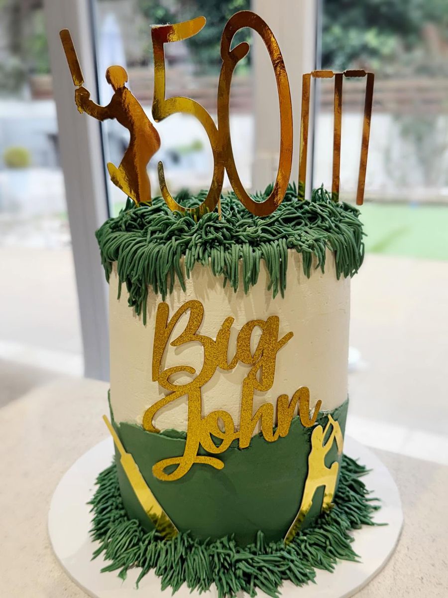 Cricket 50th cake by Just In Cakes Co. Piped grass, a gold topper and a name across the front.