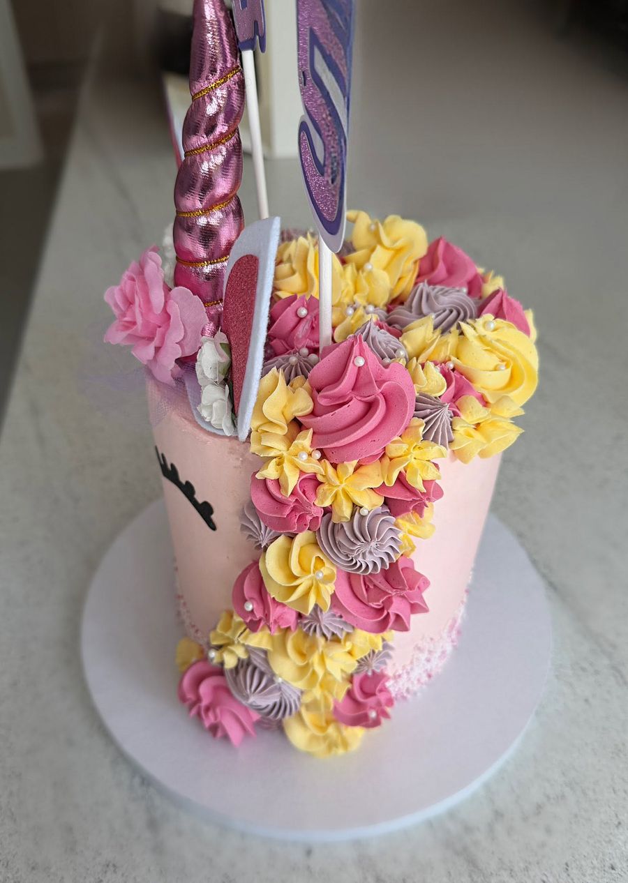 Floral unicorn cake by Just In Cakes Co. A tall unicorn with a cascade of piped flowers.