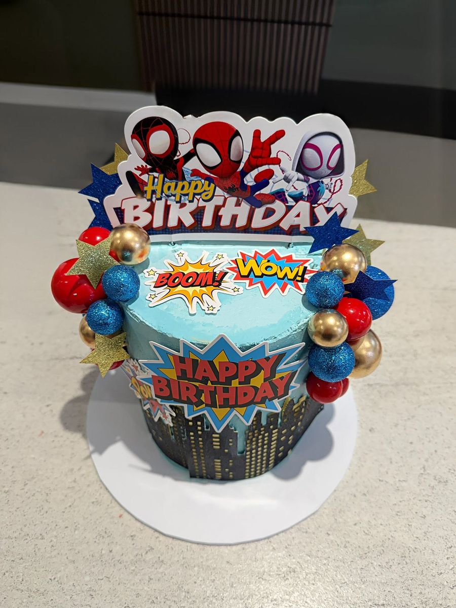 Superhero cake by Just In Cakes Co. Comic book toppers and bright baubles.