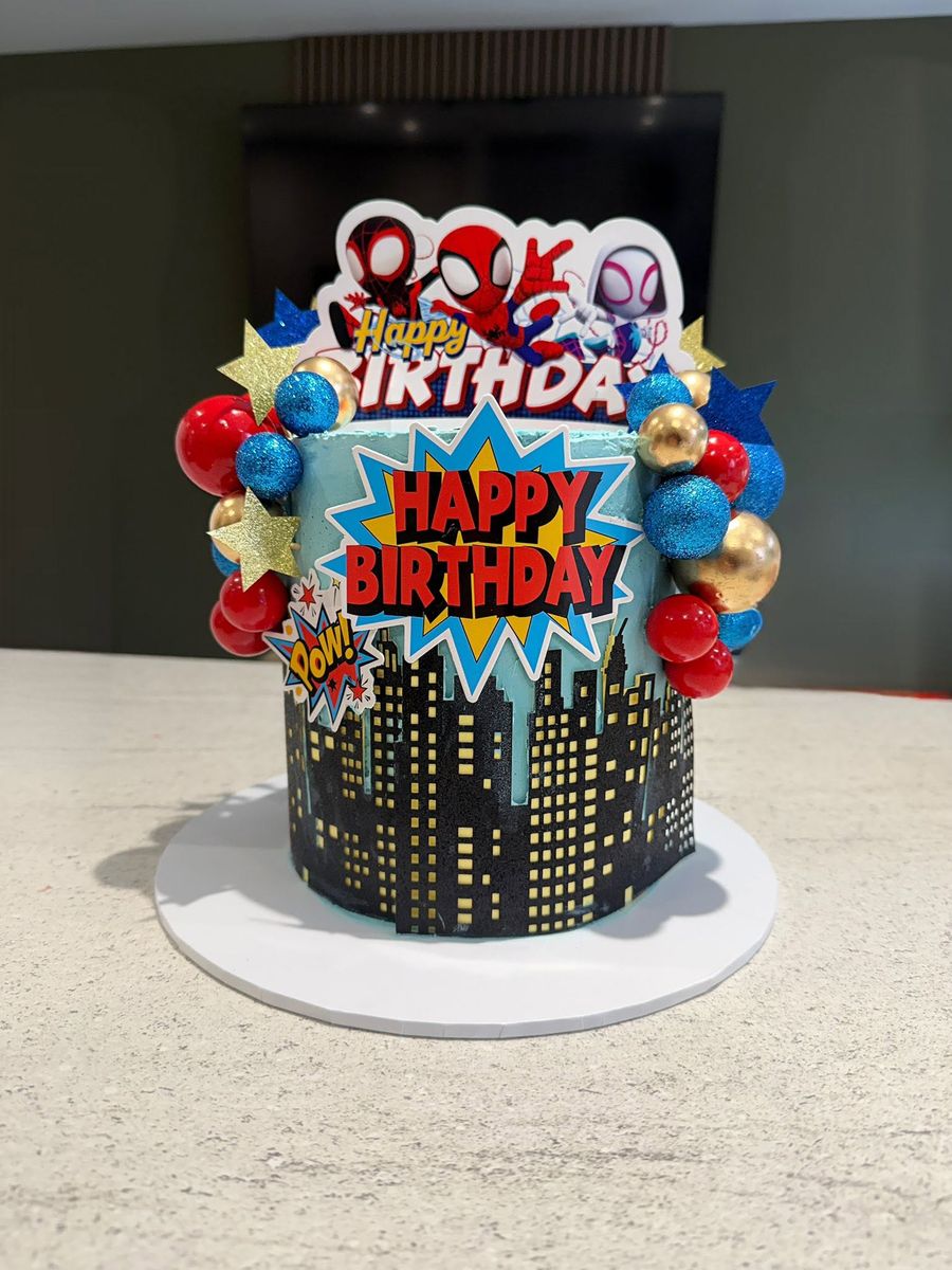 Superhero city cake by Just In Cakes Co. A night time skyline with comic book toppers.