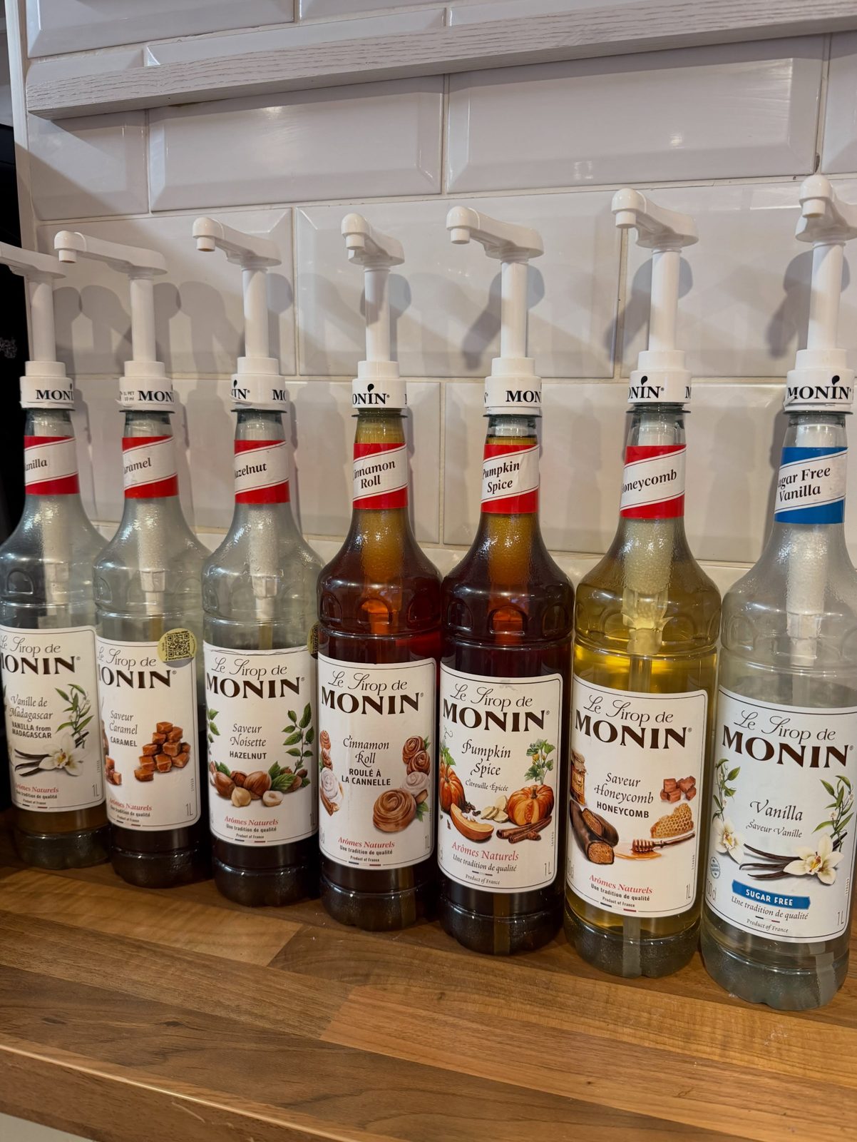 A row of coffee syrups behind the counter