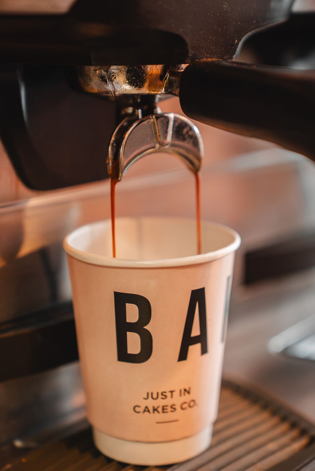 Espresso pouring into a Just In Cakes Co. takeaway cup